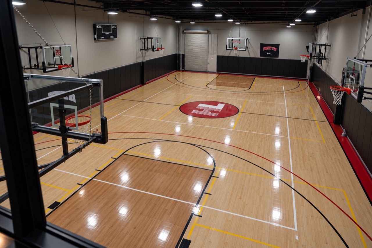 Overhead view of the full hardwood court and adjustable hoops